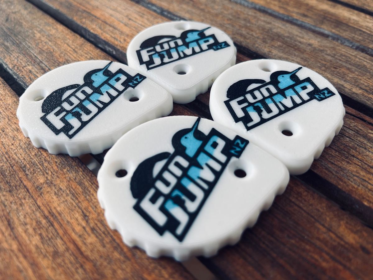 Four 3D-printed Fun Jump NZ branded tags